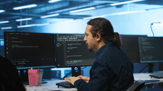Employee working in server room behind a computer